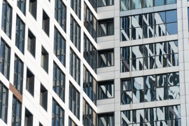 Binaların ve yapıların mimari öğelerinin arkaplan görüntüsü. Çok katlı ofis ve alışveriş merkezlerinin elementleri ve parçaları. İnşaatta yansıtıcı cam kullanımı.