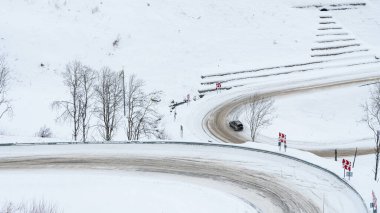 Dangerous mountain snowy road. Serpentine covered in ice. High probability of skidding. Neat car driving. Russia, Siberia, Altai Territory, Belokurikha.