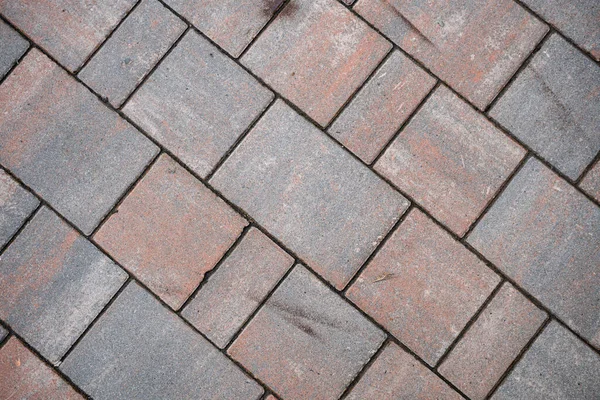 Background image of neatly laid paving slabs. Wallpaper. Substrate for text. Detailed texture of a tiled path. Paving slabs in the exterior. The surface of the road for pedestrians.