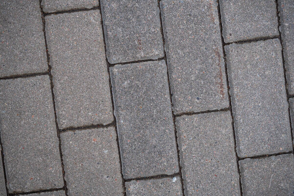 Background image of the surface of the sidewalk. Wallpaper. Substrate for text. Detailed texture of a pedestrian walkway with paving tiles. Paving slabs in the exterior. Top view.