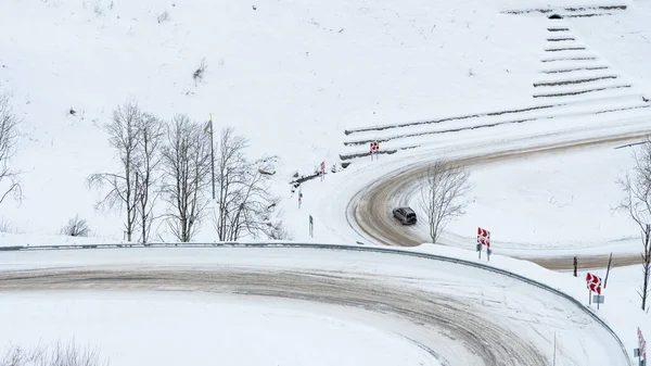 Dangerous mountain snowy road. Serpentine covered in ice. High probability of skidding. Neat car driving. Russia, Siberia, Altai Territory, Belokurikha.