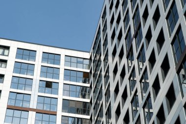 Binaların ve yapıların mimari öğelerinin arkaplan görüntüsü. Çok katlı ofis ve alışveriş merkezlerinin elementleri ve parçaları. İnşaatta yansıtıcı cam kullanımı.