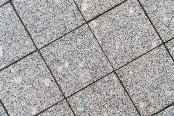 Background image of pavement surface. Wallpaper. Substrate for text. Detailed texture of a pedestrian walkway with paving tiles. Paving slabs in the exterior.