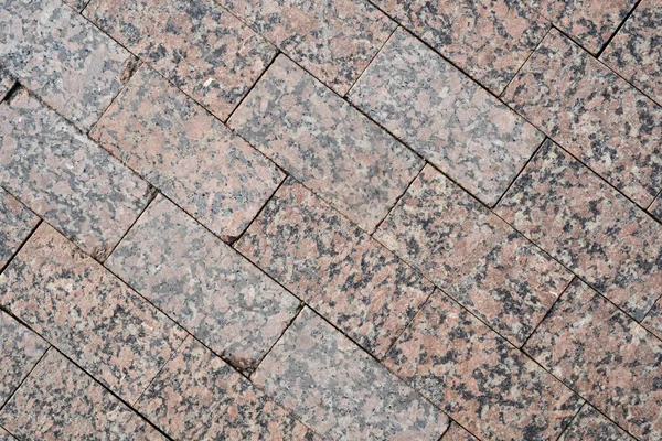 Background image of pavement cover. Detailed texture of paving marble tiles. Text space. Wallpaper. Footpath cover. Texture for the exterior. Marble tiles for the pedestrian road. Top view.