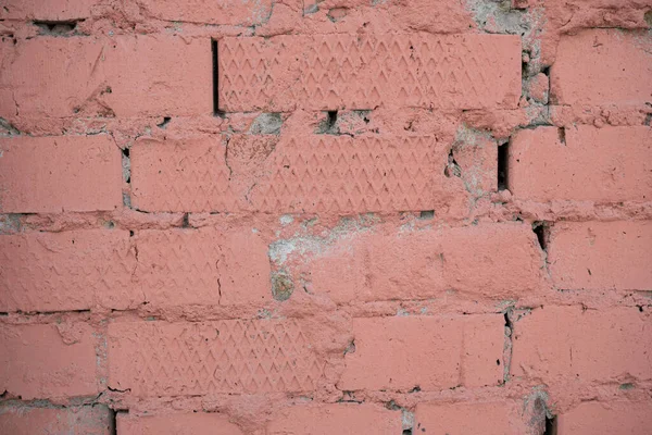 Background image of a painted brick wall. Sloppy brickwork. Detail brickwork texture. Texture for the interior. A wallpaper for the desktop. Text space. Painted in pink. Brick in construction.