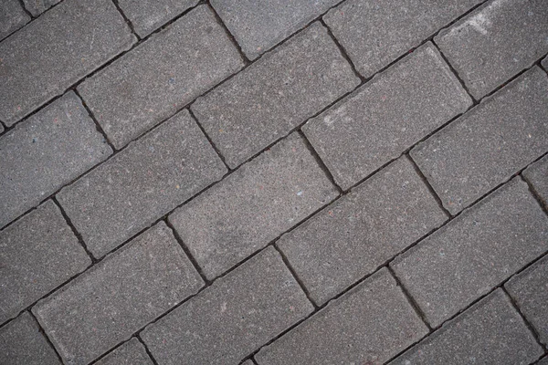 Background image of the surface of the sidewalk. Wallpaper. Substrate for text. Detailed texture of a pedestrian walkway with paving tiles. Paving slabs in the exterior. Top view.