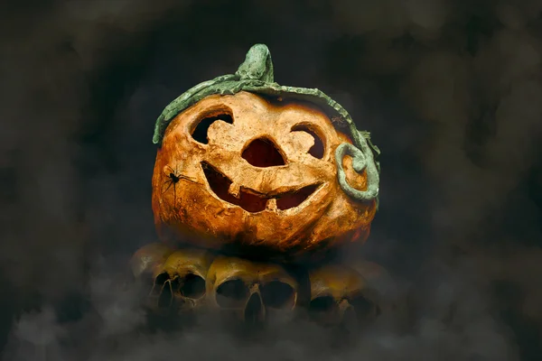 Halloween Pumpkin with Spider on a Stack of Skulls — Stock Photo, Image
