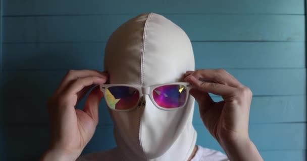 一个戴着白色乳胶面具的人戴着一副彩色眼镜 — 图库视频影像