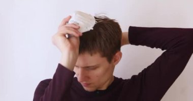 Beyaz arka plandaki adam yanlışlıkla yüzüne antiviral bir maske takıyor.