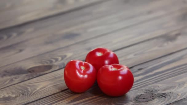 Tres Tomates Rojos Sobre Fondo Marrón Madera Pequeños Tomates Caen — Vídeos de Stock