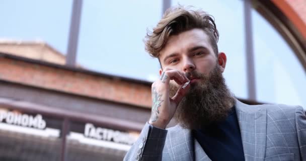 Tipo Com Barba Casaco Cinzento Fuma Cigarro — Vídeo de Stock