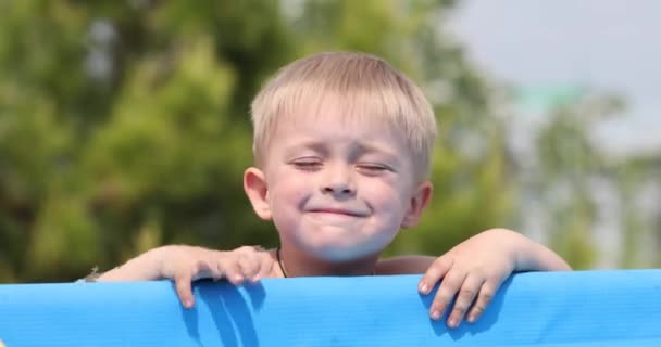 Mały Chłopiec Próbuje Wydostać Się Nadmuchiwanego Niebieskiego Basenu — Wideo stockowe