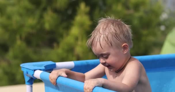Mały Chłopiec Próbuje Wydostać Się Nadmuchiwanego Niebieskiego Basenu — Wideo stockowe