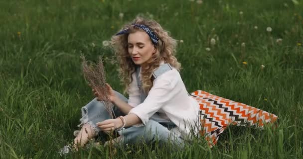 Girl Curly Hair Sits Grass Flowers Her Hands — Stock Video
