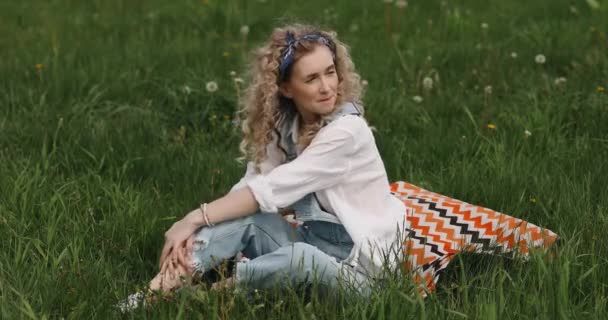 Dívka Kudrnatými Vlasy Sedí Trávě Usmívá — Stock video
