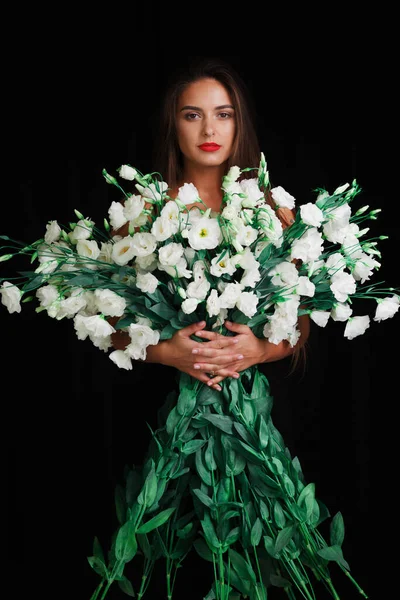 Siyah arka planda esmer, büyük bir buket güzel çiçekle. — Stok fotoğraf