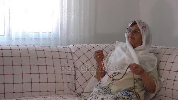 Стара жінка молиться з Розарій — стокове відео