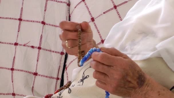 Стара жінка молиться з Розарій — стокове відео