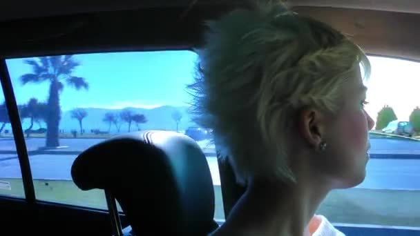 Блондинка їде всередині автомобіля в місті — стокове відео