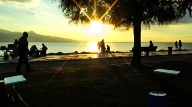 Günbatımı sahil yakınındaki insanlar siluet