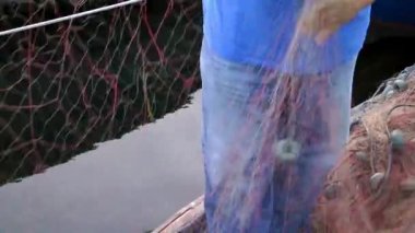 Balıkçı file çorap onarır