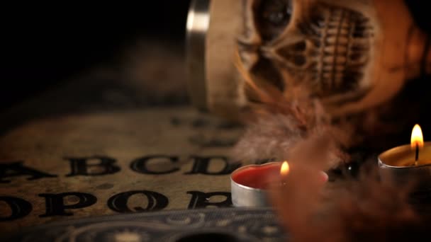 Ouijaスピリットボード上のスカルとキャンドル — ストック動画