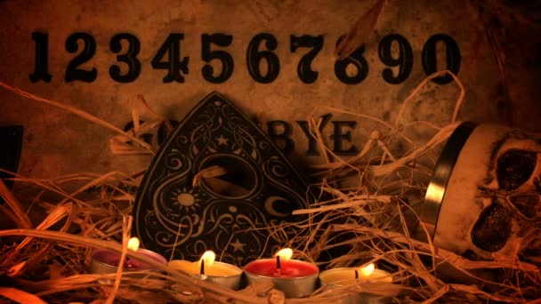 Ouijaスピリットボード上のスカルとキャンドル — ストック動画
