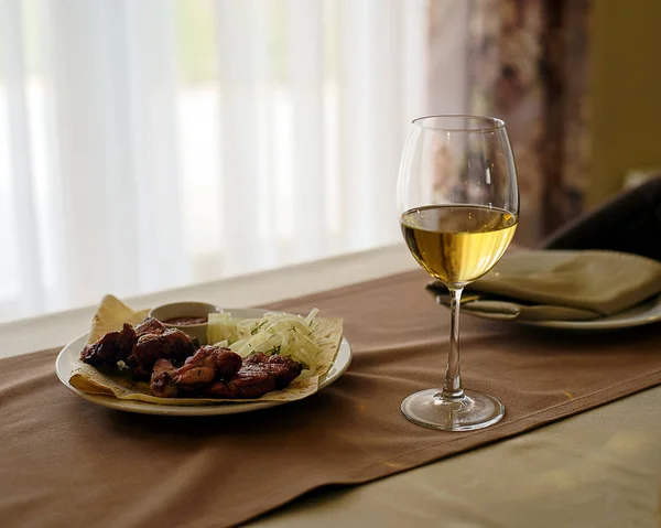 Bir bardak beyaz şarap ve lezzetli yemek.