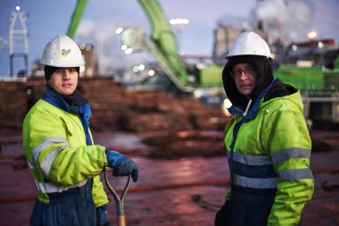  Two sailors stay on a deck during discharging pulpwood cargo from ship. Sweden, Husum 5.12.2019     clipart