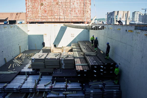 Vejle / Danimarka - 05.16.2019: kargo gemisinin ambarından çelik ürünlerin boşaltılması. Kargo Finlandiya 'dan Danimarka' ya gönderildi. Yaşlı limanlar kargo bölümünde çalışıyor.