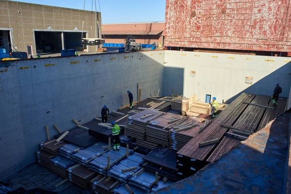 Vejle / Danimarka - 05.16.2019: kargo gemisinin ambarından çelik ürünlerin boşaltılması. Kargo Finlandiya 'dan Danimarka' ya gönderildi. Yaşlı limanlar kargo bölümünde çalışıyor.