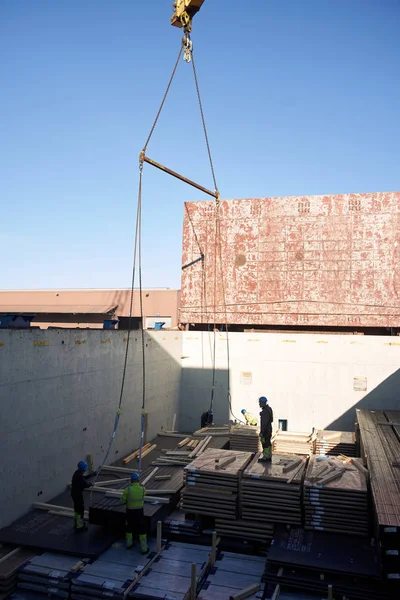 Vejle / Danimarka - 05.16.2019: kargo gemisinin ambarından çelik ürünlerin boşaltılması. Kargo Finlandiya 'dan Danimarka' ya gönderildi. Yaşlı limanlar kargo bölümünde çalışıyor.