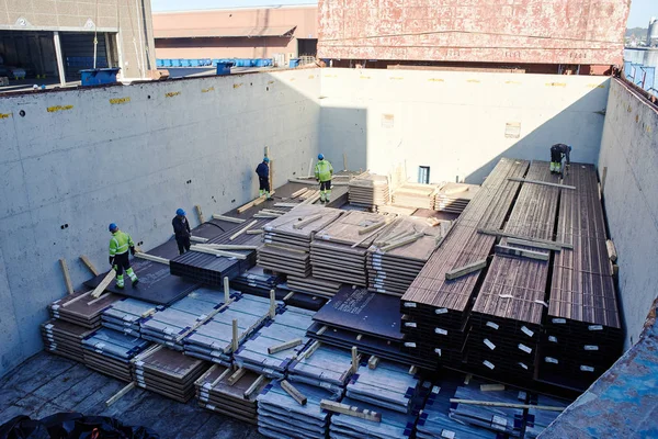 Vejle / Danimarka - 05.16.2019: kargo gemisinin ambarından çelik ürünlerin boşaltılması. Kargo Finlandiya 'dan Danimarka' ya gönderildi. Yaşlı limanlar kargo bölümünde çalışıyor.