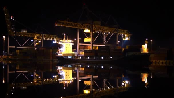 ギャル/スウェーデン- 12.23.2019:排出操作中のポート内のコンテナ船係留。船からコンテナを排出するポートクレーン。港での夜間勤務. — ストック動画