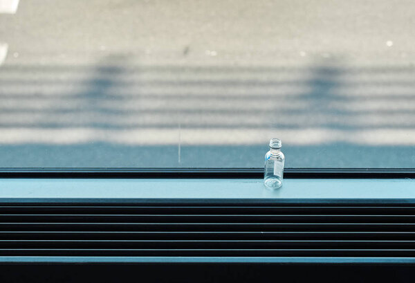 Небольшая пустая стеклянная бутылка алкоголя в аэропорту на заднем плане аэродрома
.