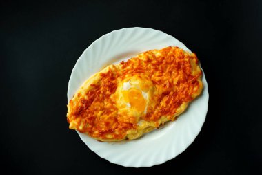 Taze sebze salatası ve beyaz tabakta koyu bir arka planda khachapurin. Yakın plan..