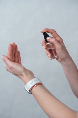 Bakteri, bakteri ve virüs yayılmasını önlemek için elinde alkol spreyi ya da anti bakteri spreyi olan bir kadın eli. Kişisel hijyen konsepti. Temizleyici.