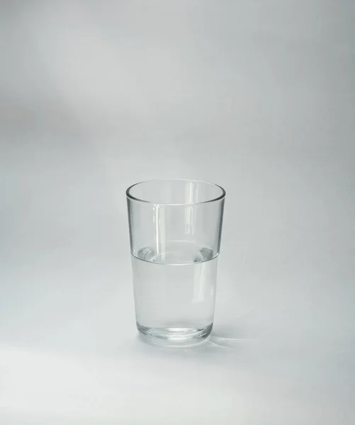 Glass Cup Half Full Water Stands Light Background Close Copy — Stock Photo, Image