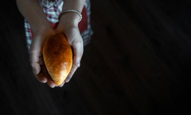 Taze pişmiş elmalı turta kızın avuçlarında yatıyor. Kız kirli elleriyle bir turta tutuyor. Yakın plan. Boşluğu kopyala