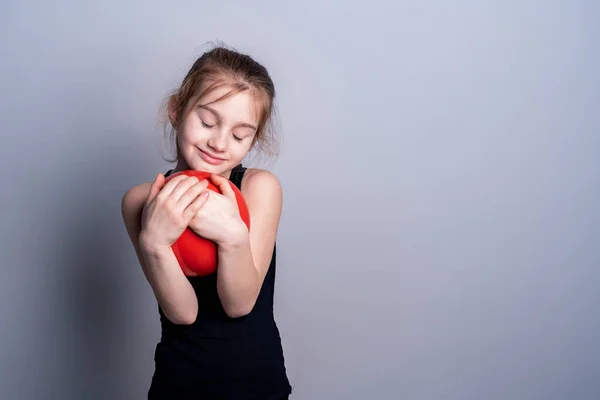 Белокожая Девушка Чёрной Тренировочной Рубашке Держит Красный Гимнастический Мяч Прижимает — стоковое фото