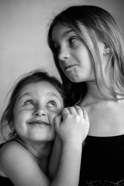 İki küçük Systerichka kızının siyah beyaz portresi. Birbirlerine sarılıp neşeyle gülüyorlar. Aile değerleri. Arkadaşlık. Neşe