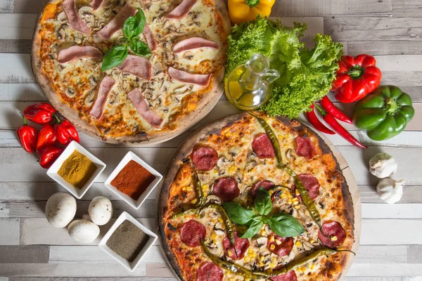 İki pizza ve malzemeler ahşap arka plan, kompozisyonu
