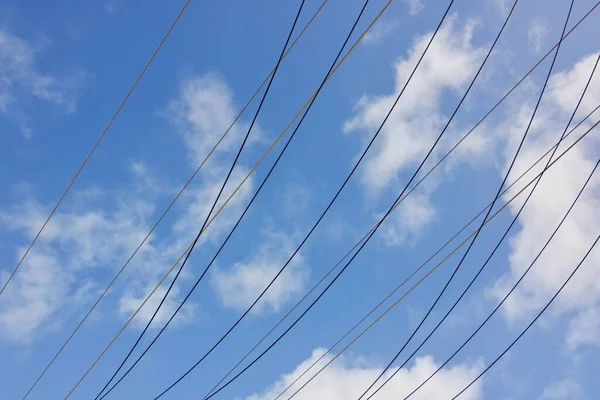 Electric power cables against blue cloudy sky with copy space — ストック写真