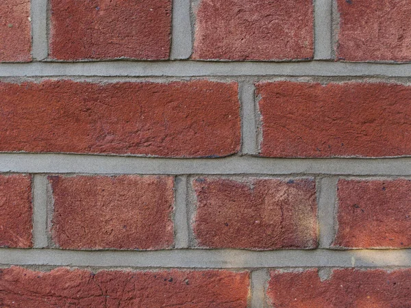 Fechar de tijolos vermelhos grosseiros com argamassa cinza — Fotografia de Stock