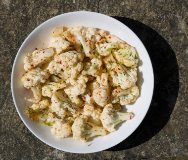 Çiğ karnabahar manzarasına yukarıdan kırmızı biber serpilmiş.