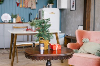 Yeni yıl için dekore edilmiş yemek odasındaki sehpanın üzerindeki Noel ağacı.