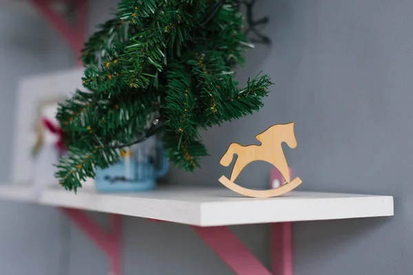 Wooden toy horse made of plywood is on the shelf in the room