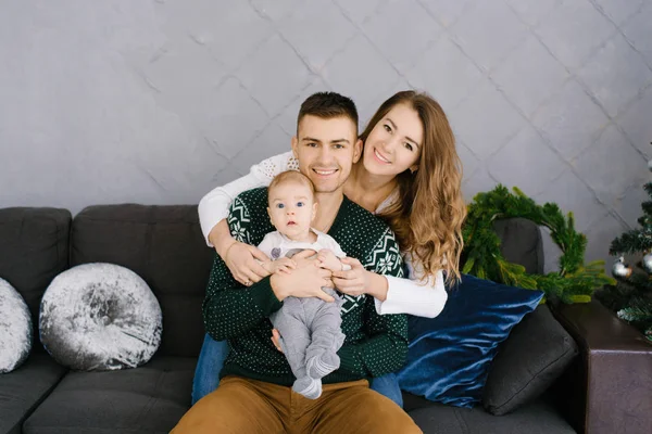 Mutlu Genç Bir Aile Oturma Odasında Kollarında Bir Bebekle Noel — Stok fotoğraf