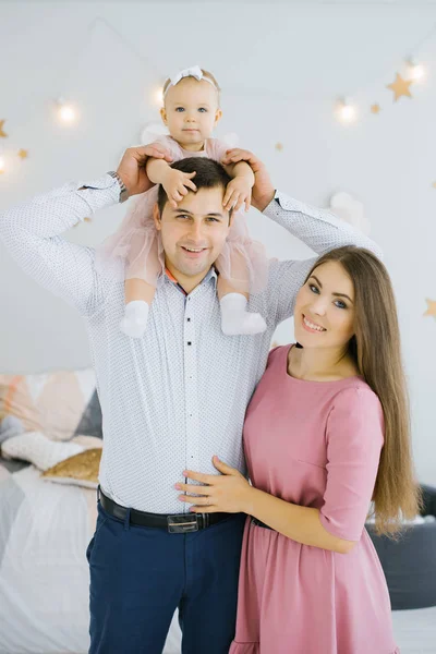 父親の肩に座っている小さな娘を持つ陽気な幸せな若い家族 幸せな両親と子供時代 — ストック写真