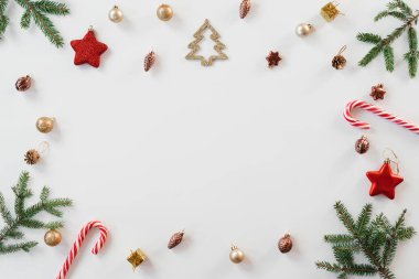 Parlak Noel çerçevesi ladin, kahverengi ve altın rengi Noel süsleri, beyaz arka planda nane şekeri. Uzayı kopyala Kış tatili, yeni yıl.